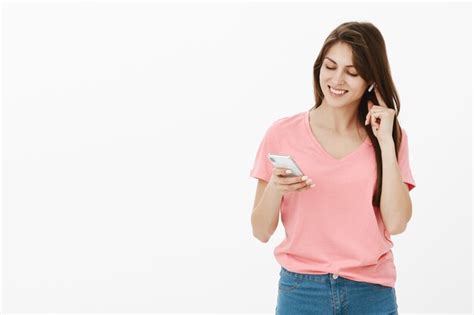 Free Photo Brunette Woman Posing In The Studio With Her Phone And Earbuds