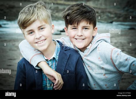 Two Brothers Boys 12 And 10 Years By The Sea Hugging Facing The