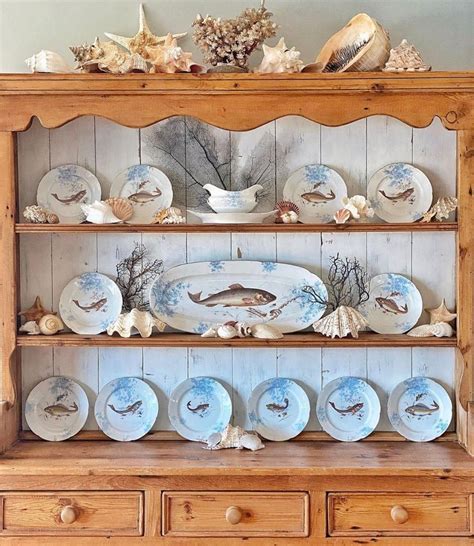 A China Cabinet Filled With Plates And Seashells On Top Of Wooden