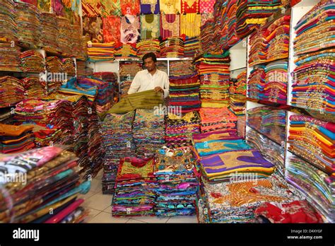 Man folding fabric in textile shop, Dubai, United Arab Emirates Stock ...