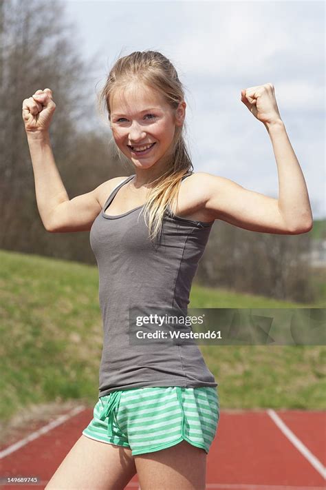 Austria Teenage Girl On Track Showing Her Muscles Smiling Portrait Foto