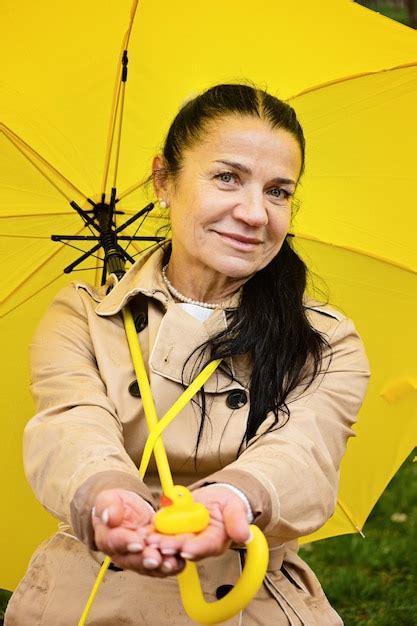 Mulher S Nior Feliz Em Capa De Chuva Amarela Guarda Chuva Amarelo