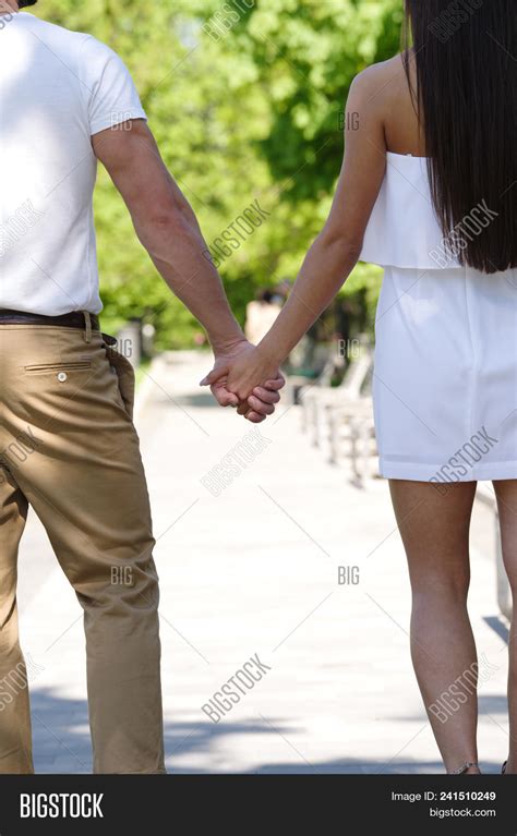 Man And Woman Walking Holding Hands