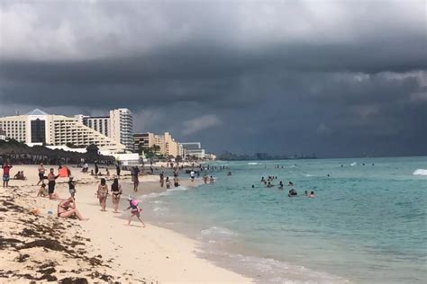 Bañistas arriban a Playa Delfines en Cancún pese a la amenaza de