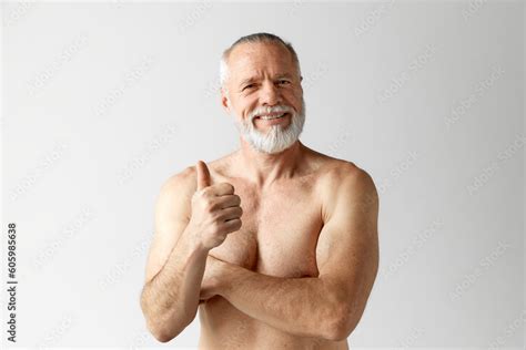 Portrait Of Handsome Mature Shirtless Muscular Man With Beard And Gray Hair Posing Against