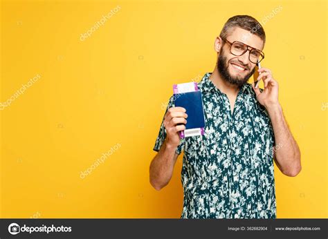 Smiling Bearded Guy Glasses Passport Ticket Talking Smartphone Yellow