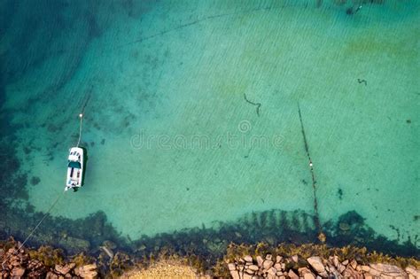 Aerial Top View Of A Boat Docked On The Water By A Coast In Donegal