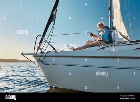 Sailing Alone Side View Of A Relaxed Senior Man Sitting On The Side Of