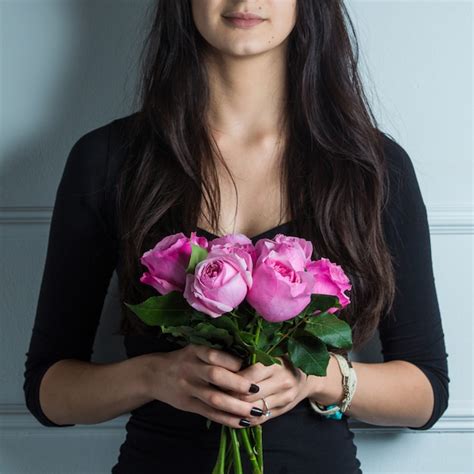 Mujer Vestida De Negro Con Un Ramo De Rosas Rosadas Foto Gratis