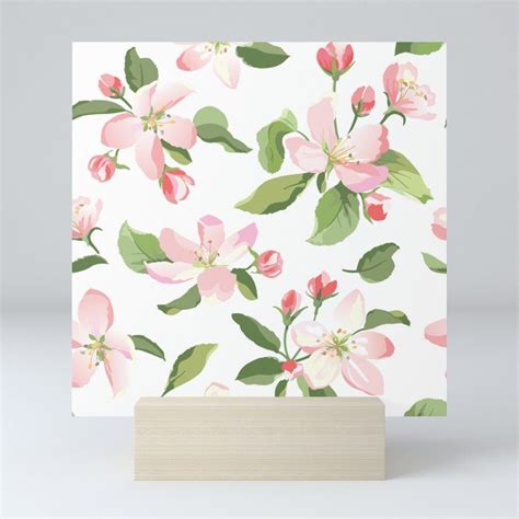 A White Card With Pink Flowers And Green Leaves On It Sitting On A