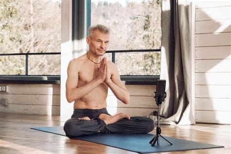 Premium Photo Senior Man With A Naked Torso Practices Yoga Lesson Via
