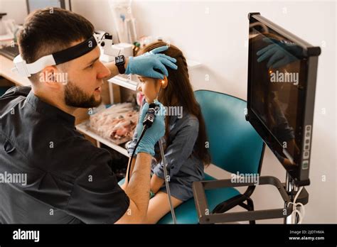 Ears endoscopy of child. Otoscopy procedure with otoscope. ENT doctor otolaryngologist treat ...