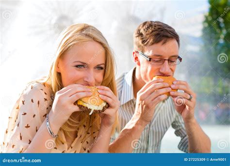 Couple Is Hungry And Eating A Burger At Break Stock Image Image Of