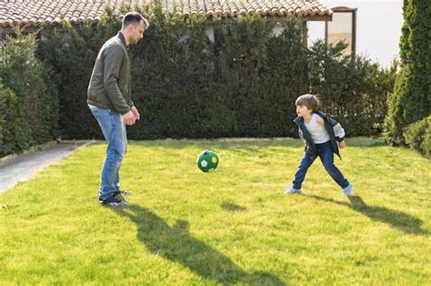 Padre E Hijo Jugando Con Pelota Foto Gratis