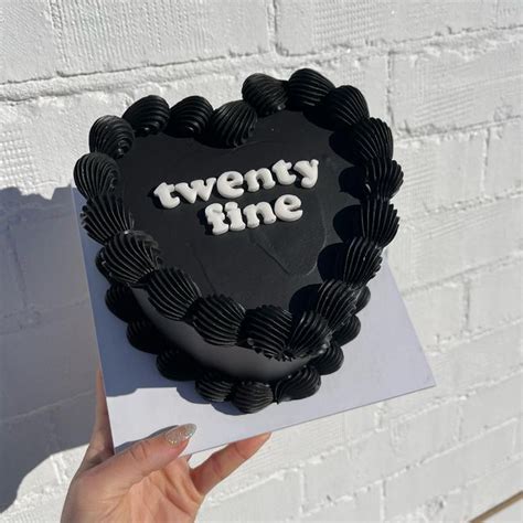 A Heart Shaped Cake With The Words Twenty Nine On It Held By A Woman S