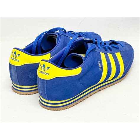 A Pair Of Adidas Originals Spezial Zurro Blue And Yellow Trainers In