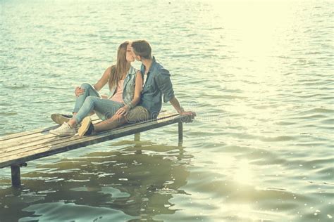 Couple In Love Sitting On The Pier Embrace Stock Image Image Of