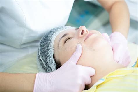 Woman Has A Facial Massage In A Beauty Clinic Beautician Doing Facial