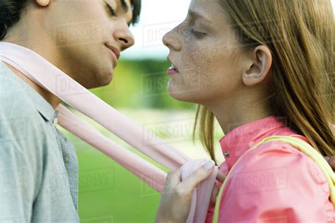 Young Couple Leaning In To Kiss Eyes Closed Side View Stock Photo