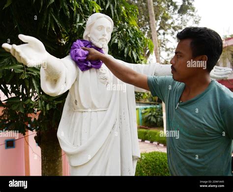 A worker cleaning a statue of Jesus Christ at a church in preparation ...