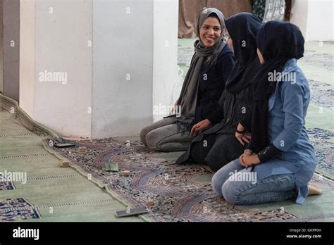 Young Iranian Women Wearing Hijabs Kneel To Pray With Their Cell Phones