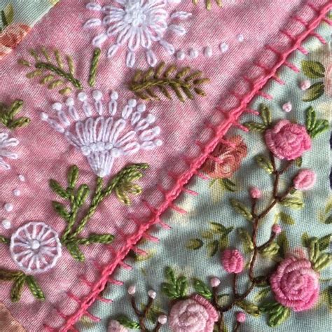 The Corner Of A Piece Of Fabric With Flowers And Leaves Embroidered On