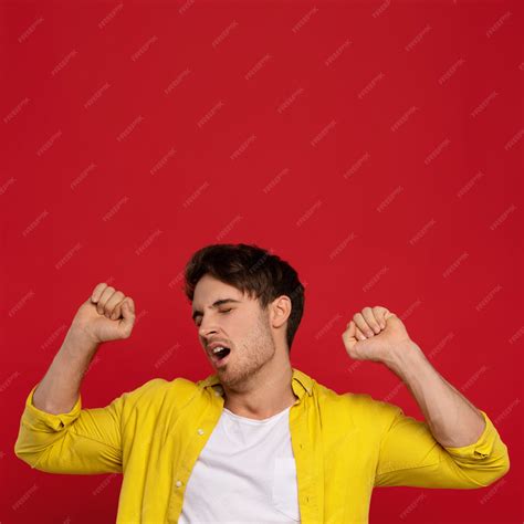 Premium Photo Excited Man In Yellow Shirt Yawning With Closed Eyes