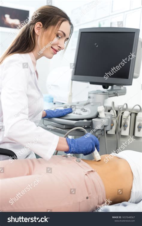 Young Doctor Examining Stomach Female Patient Stock Photo 1657648567