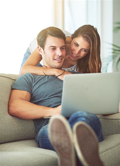 Enjoying A Chilled Out Day Together A Young Couple Using A Laptop At