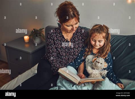 Mother Reading Book Her Daughter In Bed Before Going To Sleep Reading