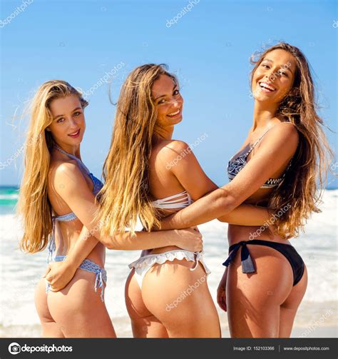 Tres chicas en trajes de baño en la playa fotografía de stock