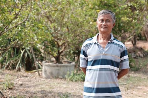 Premium Photo Portrait Of Smiling Man Standing Against Plants