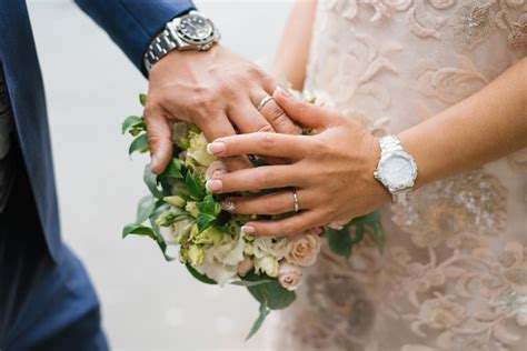 Las manos de la novia y el novio están en el ramo de boda Foto Premium