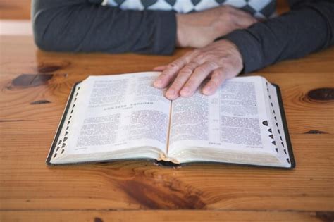 Premium Photo Senior Man Praying Reading An Old Bible Hands Folded