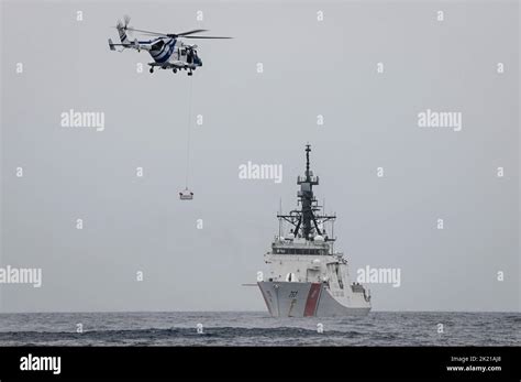 A Search And Rescue Helicopter From The Indian Coast Guard Hovers Above