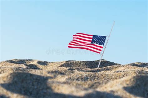 American Flag In The Sand Against A Blue Sky Concept Stock Photo