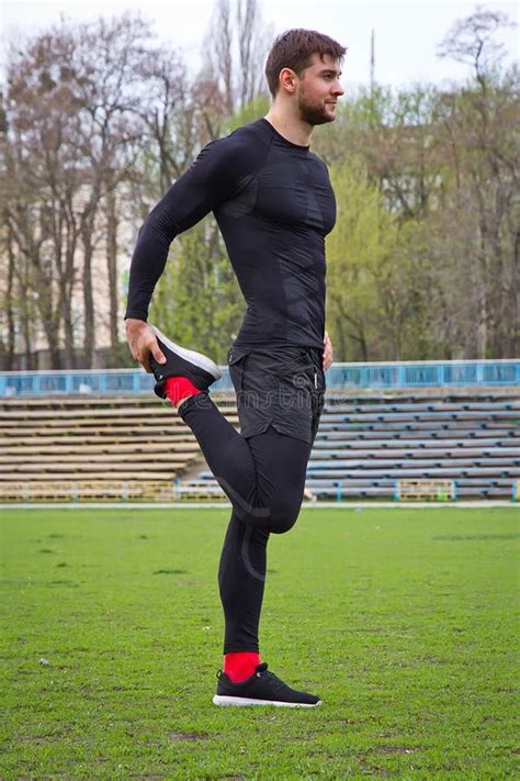 Atleta Atractivo Joven Del Hombre Que Calienta En El Estadio Foto De