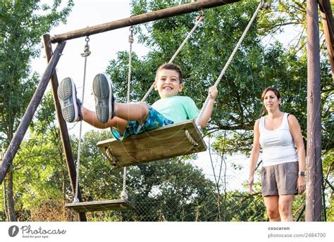 Mother Swinging Her Son On A Swing A Royalty Free Stock Photo From