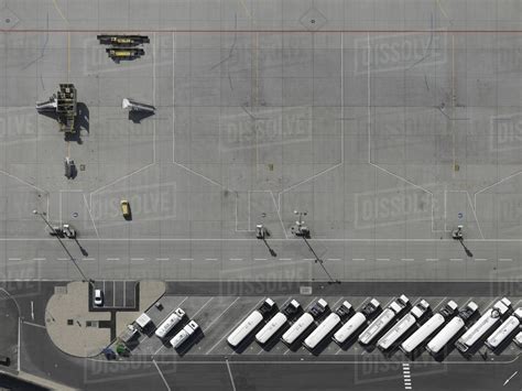 Aerial view service vehicles parked on tarmac at airport - Stock Photo - Dissolve