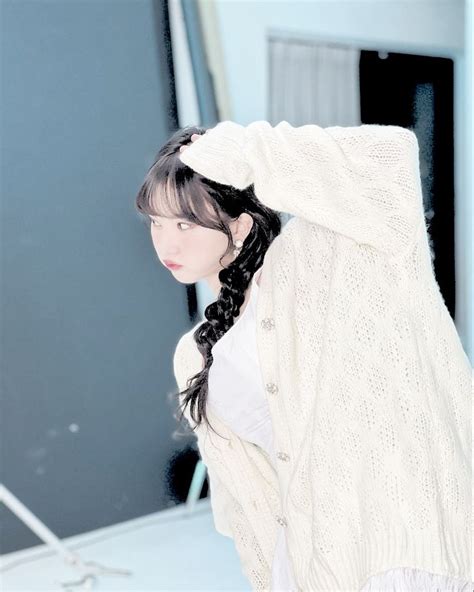 A Woman With Long Black Hair Wearing A White Sweater And Braid In Front