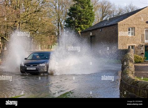 Flooding Woman Driving Black Car Splashing Through Deep Flood Water