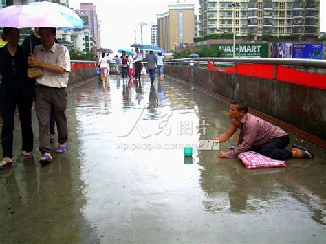 深圳：一行乞者暴风雨中跪地乞讨 人民图片网