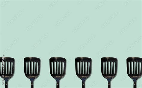 light blue background with black kitchen spatula Stock Photo | Adobe Stock