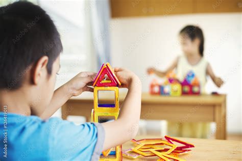 Two children building using geometric shapes. Stock Photo | Adobe Stock