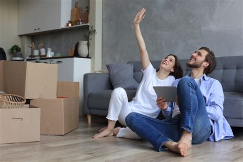 Premium Photo Happy Couple Sitting And Planning New Home Decoration At Home With A Tablet At