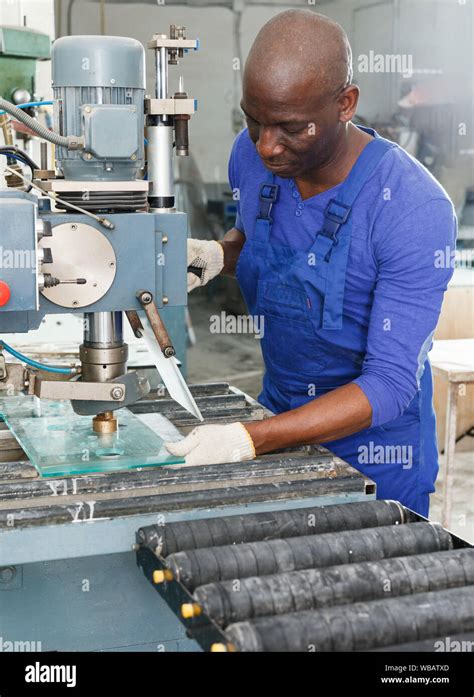 Serious African American Craftsman Working On Glass Drilling Machine