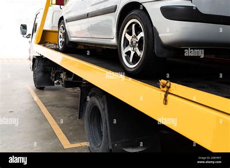 Broken Car On Flatbed Tow Truck Being Transported For Repair Stock