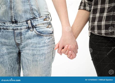 Two Girls In Jeans Hold Hands Close Up White Background Homosexual