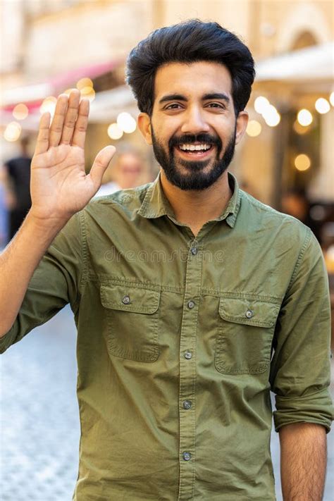 Young Man Smiling Friendly At Camera Waving Hands Hello Hi Greeting