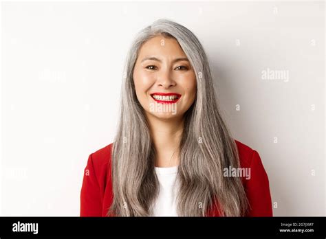 Close Up Of Elegant Mature Woman In Red Blazer And Makeup Smiling